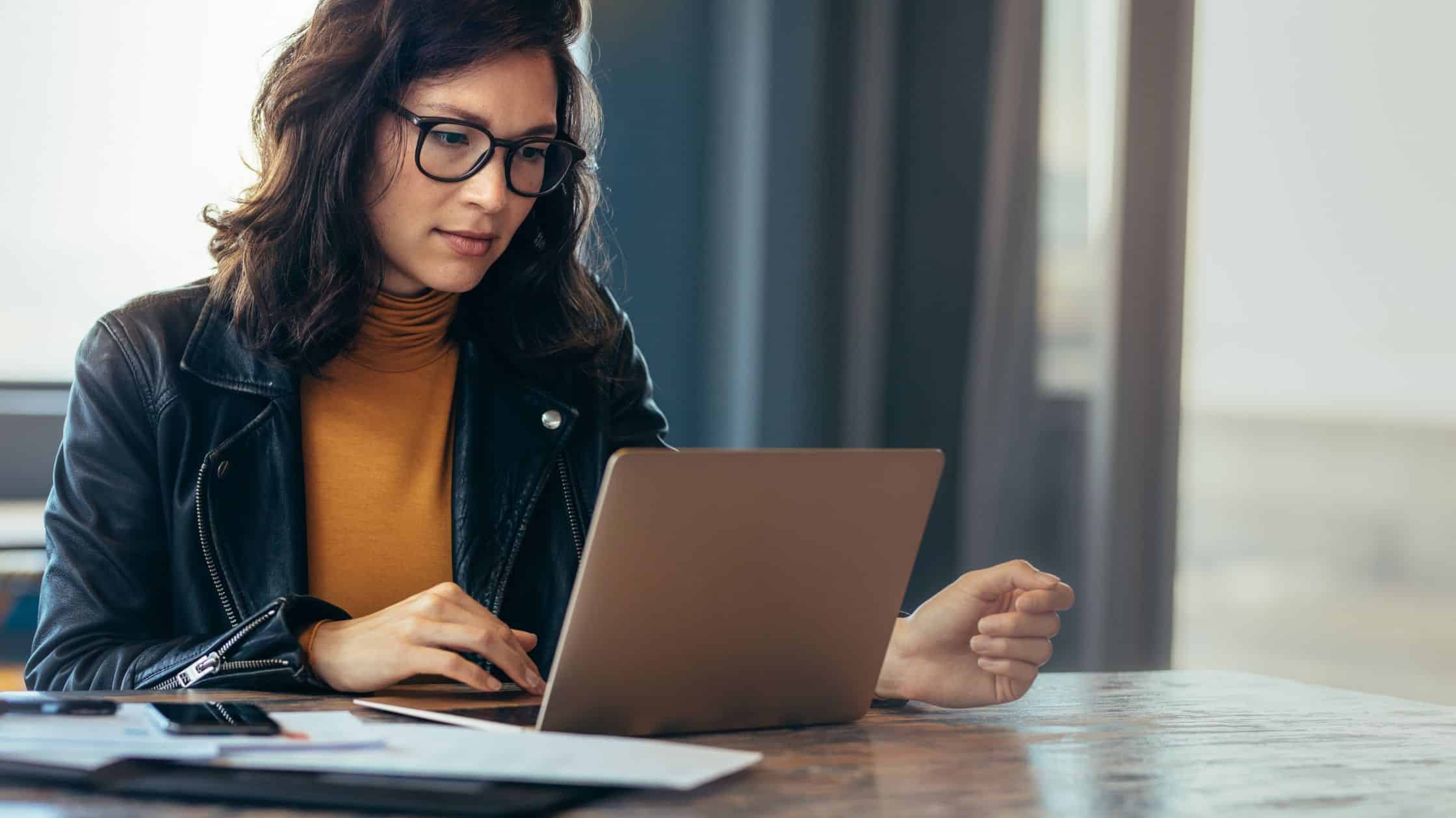 A professional woman working at a laptop.