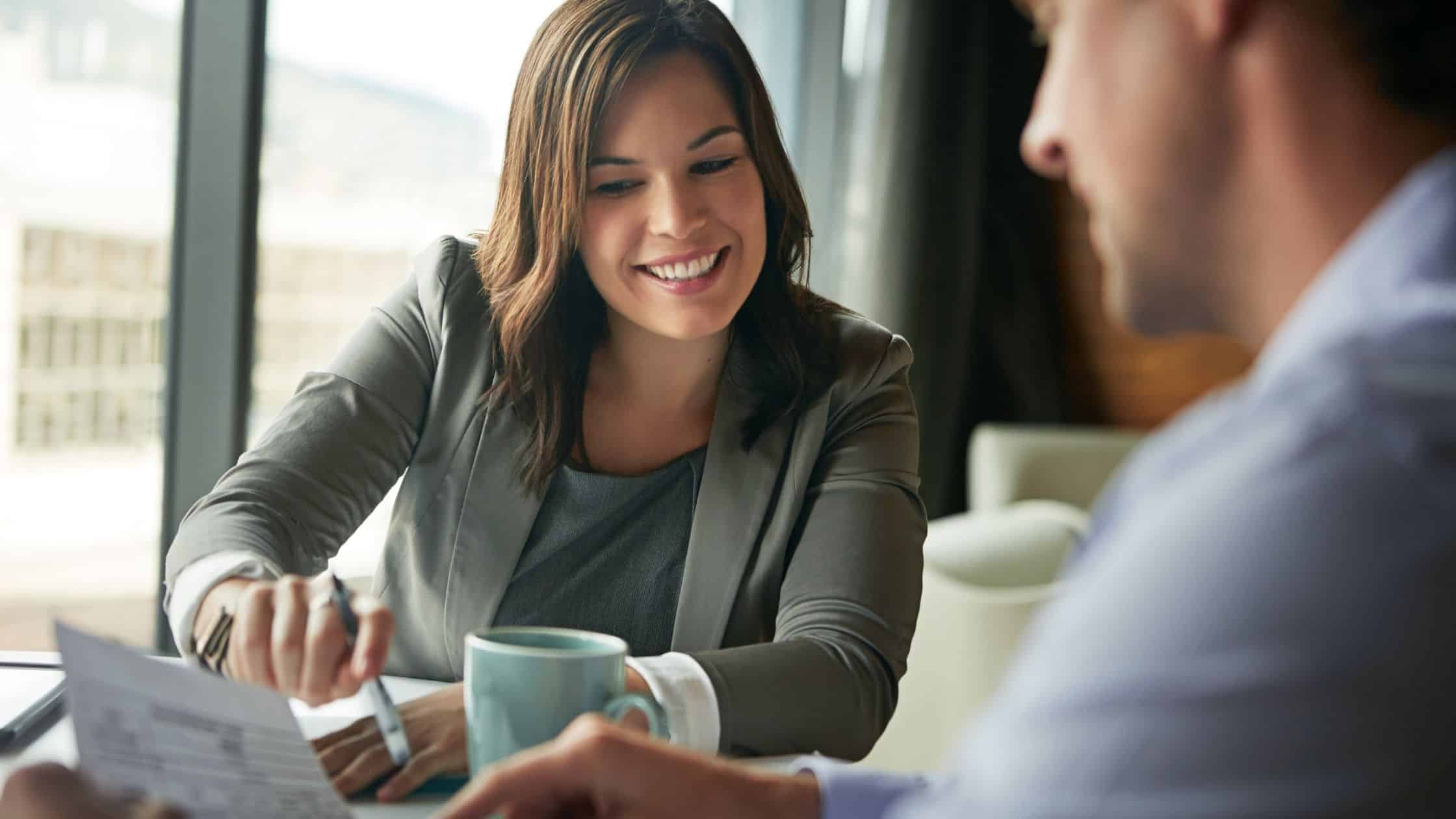 Two professionals discussing a financial report over a desk.