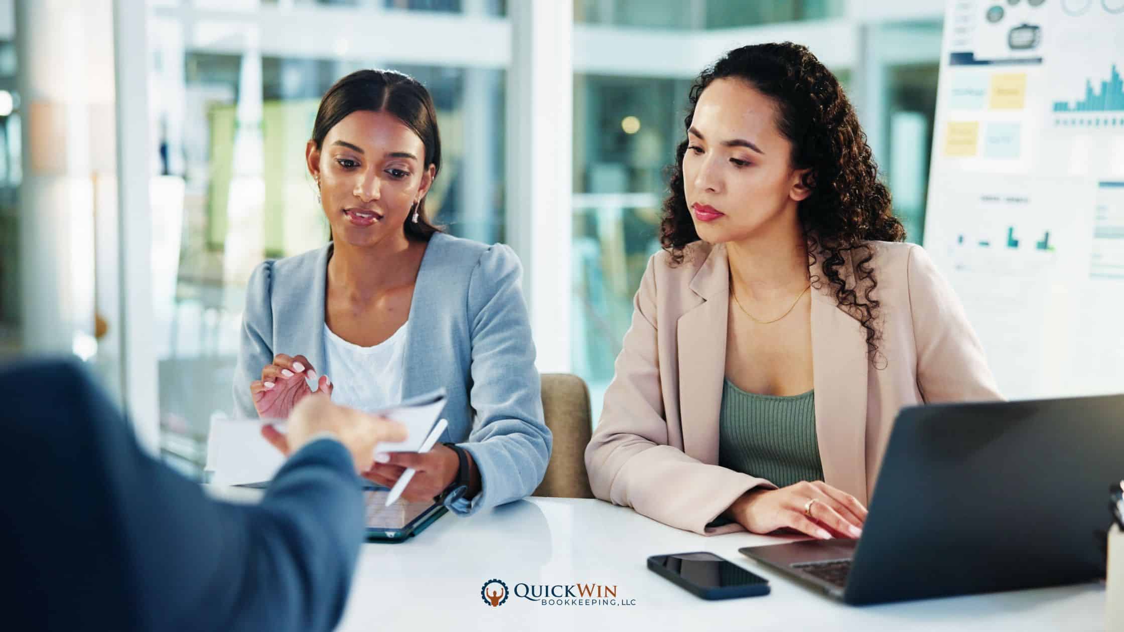 Two bookkeepers discussing financials with a client.
